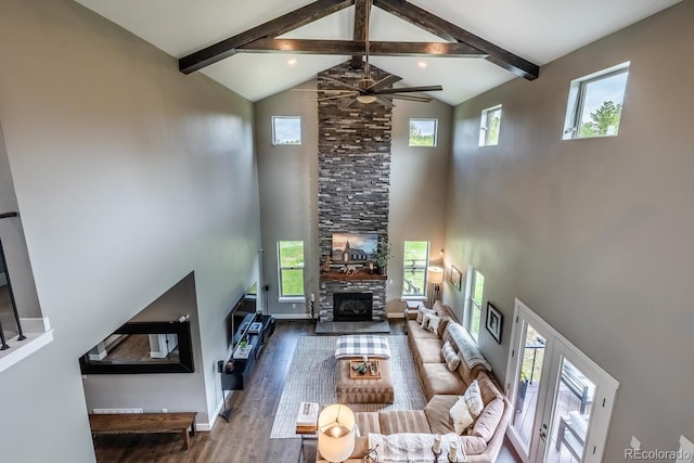 230 S Big Meadow Trl, Franktown, CO 80116 - living room with high vaulted ceiling, beam ceiling, a stone fireplace, a ceiling fan, and wood finished floors