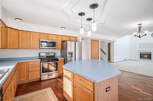 kitchen featuring a center island, stainless steel appliances, an inviting chandelier, dark hardwood / wood-style flooring, and decorative light fixtures