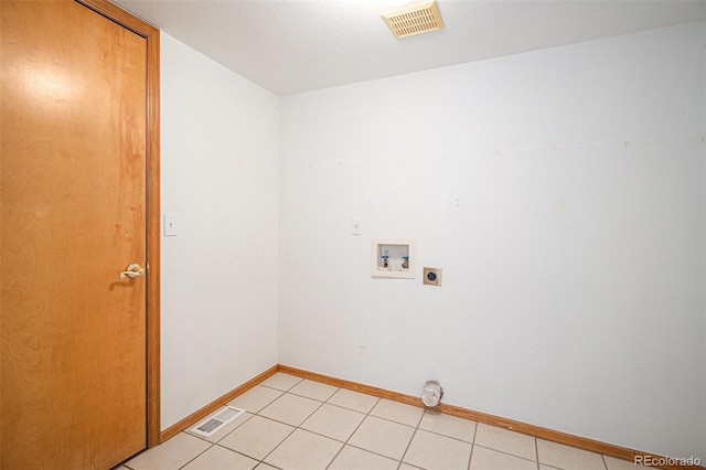 laundry area featuring light tile patterned flooring, washer hookup, a textured ceiling, and hookup for an electric dryer