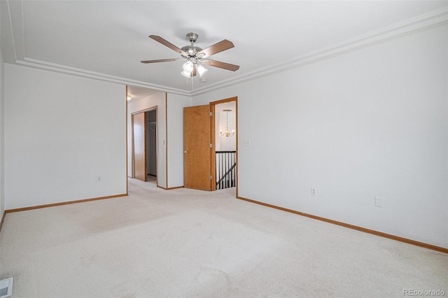 carpeted empty room featuring ornamental molding and ceiling fan