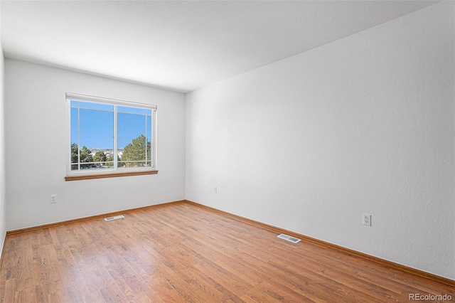 empty room with light hardwood / wood-style flooring