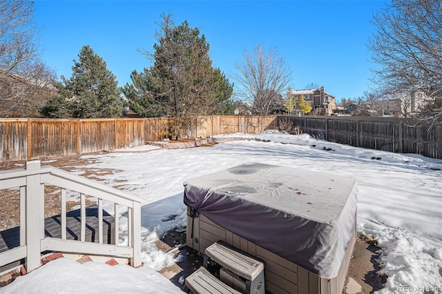 yard covered in snow featuring a hot tub