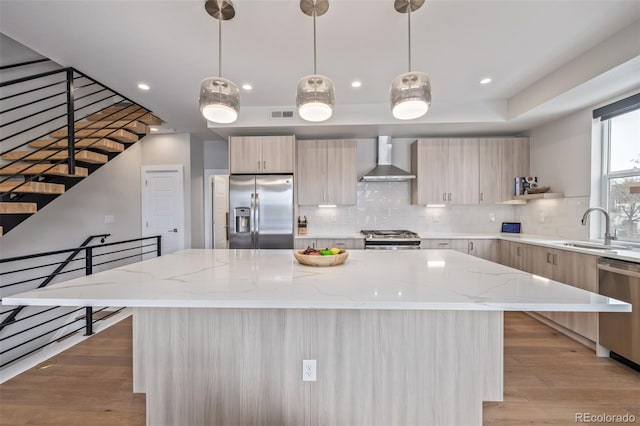 2350 Tremont Pl Unit 13, Denver, CO 80205 - kitchen with appliances with stainless steel finishes, wall chimney range hood, modern cabinets, decorative backsplash, and a center island