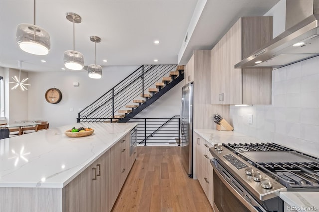 2350 Tremont Pl Unit 13, Denver, CO 80205 - kitchen featuring stainless steel appliances, wall chimney range hood, modern cabinets, light wood-type flooring, and recessed lighting