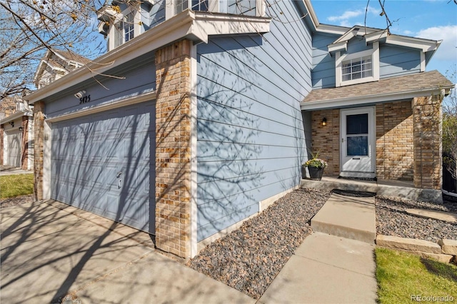 5425 W 115th Pl, Westminster, CO 80020 - view of front of home featuring an attached garage, driveway, brick siding, roof with shingles, and a porch