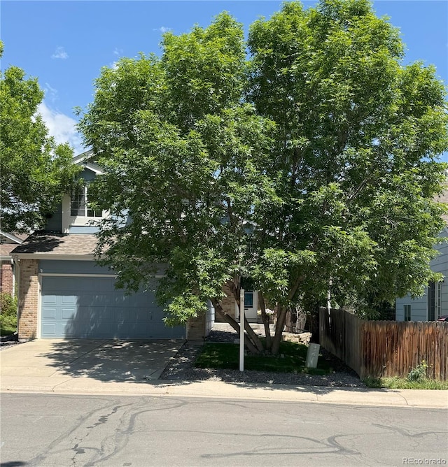 5425 W 115th Pl, Westminster, CO 80020 - obstructed view of property with concrete driveway, brick siding, and a garage