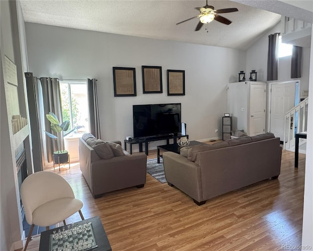5425 W 115th Pl, Westminster, CO 80020 - living room featuring lofted ceiling, light wood-type flooring, a ceiling fan, a textured ceiling, and a fireplace