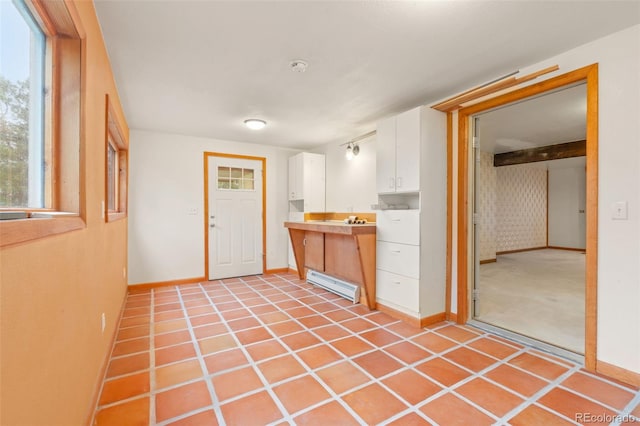 723 Brussels Dr, Parker, CO 80138 - kitchen with white cabinetry, baseboard heating, and light countertops