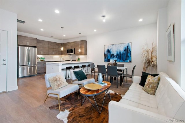 living room with light wood-type flooring and sink