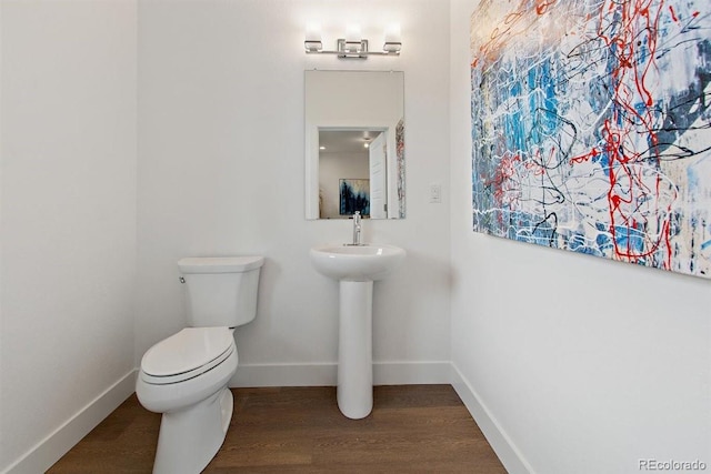 bathroom featuring wood-type flooring and toilet