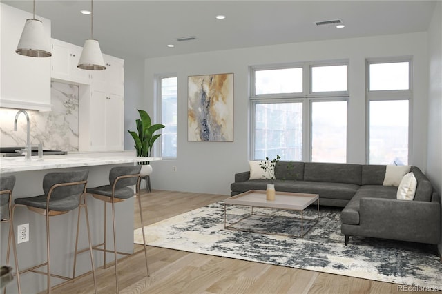 living room with light hardwood / wood-style floors and sink