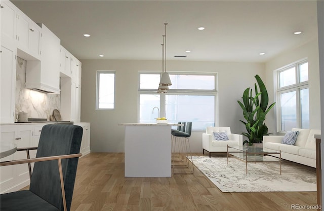 kitchen with plenty of natural light, light wood-type flooring, white cabinetry, and decorative light fixtures