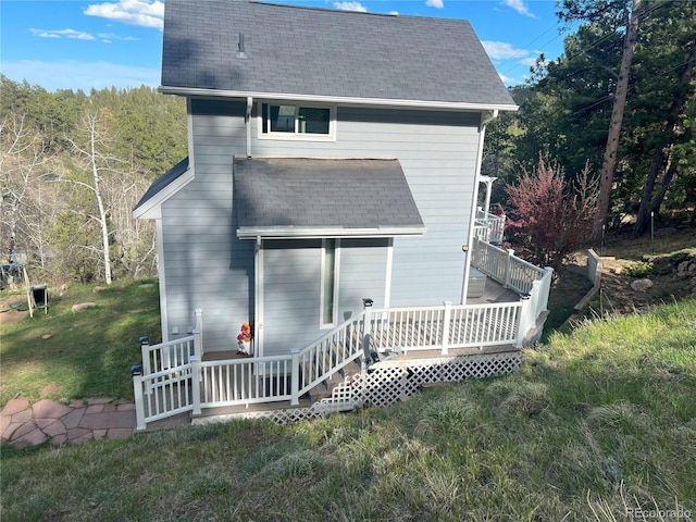 137 Bob Cat Trl, Bailey, CO 80421 - back of house featuring roof with shingles, a yard, a deck, and a forest view