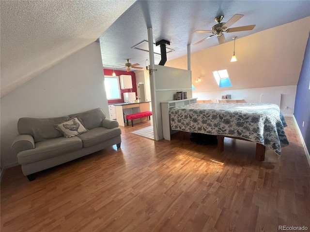 137 Bob Cat Trl, Bailey, CO 80421 - bedroom with wood finished floors, vaulted ceiling, a textured ceiling, a skylight, and ceiling fan