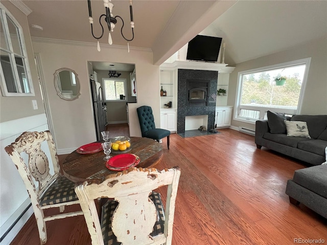 137 Bob Cat Trl, Bailey, CO 80421 - living room featuring wood finished floors, baseboard heating, a chandelier, ornamental molding, and plenty of natural light