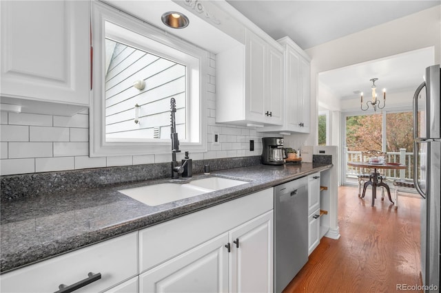 137 Bob Cat Trl, Bailey, CO 80421 - kitchen with stainless steel appliances, a sink, white cabinetry, a chandelier, and tasteful backsplash