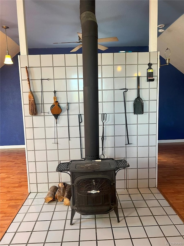 137 Bob Cat Trl, Bailey, CO 80421 - detailed view of a ceiling fan, wood finished floors, tile walls, baseboards, and a wood stove