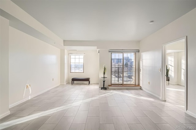 empty room with plenty of natural light and light tile patterned flooring