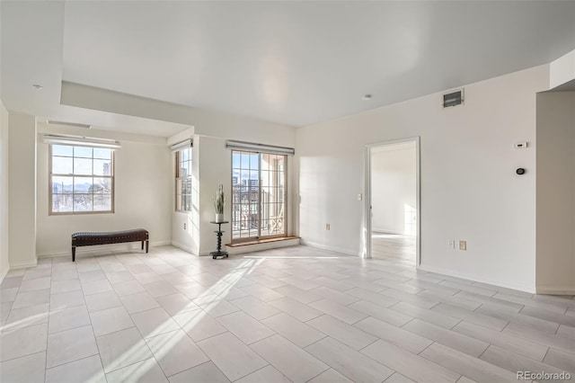 spare room featuring a wealth of natural light and light tile patterned flooring