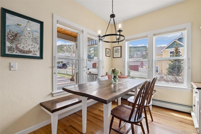 45 Bridge St, Breckenridge, CO 80424 - dining area featuring a chandelier, a baseboard radiator, light wood-type flooring, and baseboards