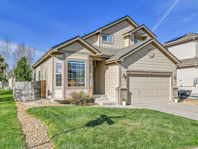 traditional-style home with driveway, fence, an attached garage, a shingled roof, and a front lawn