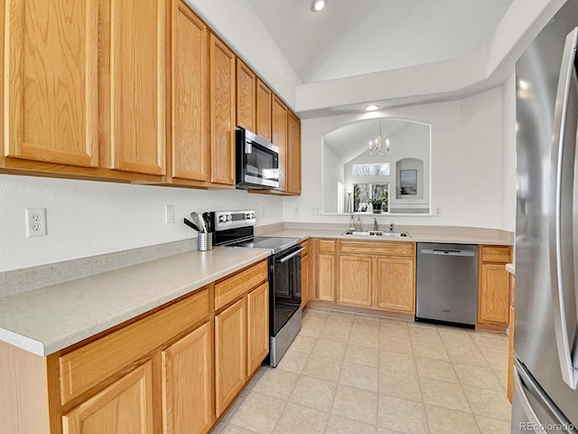 kitchen with a sink, lofted ceiling, an inviting chandelier, light countertops, and appliances with stainless steel finishes