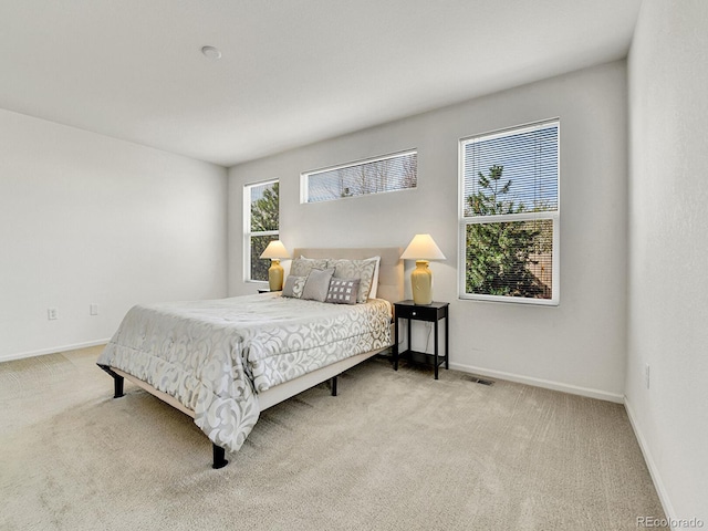 carpeted bedroom featuring visible vents and baseboards