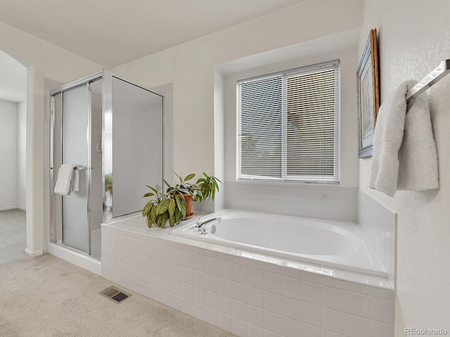 full bathroom with a bath, a shower stall, and visible vents