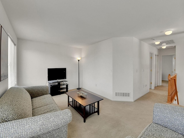 living area featuring light colored carpet, visible vents, and baseboards