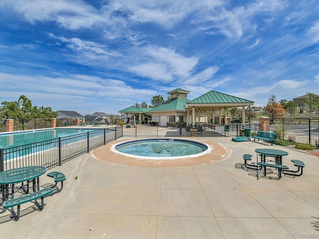 pool featuring fence and a gazebo