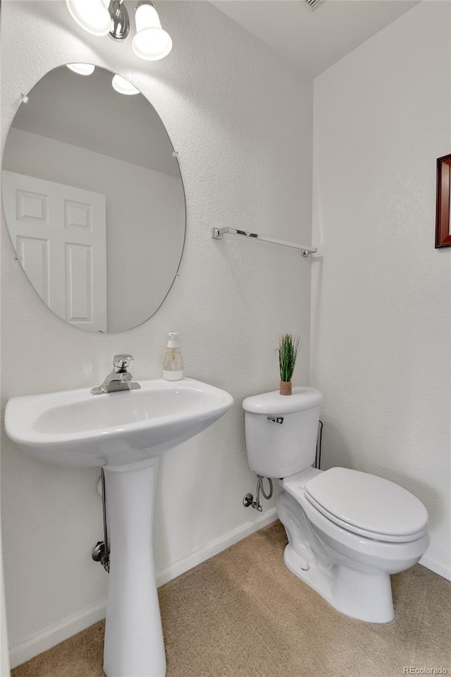 bathroom with toilet and baseboards