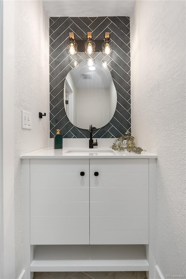 bathroom featuring a sink and a textured wall
