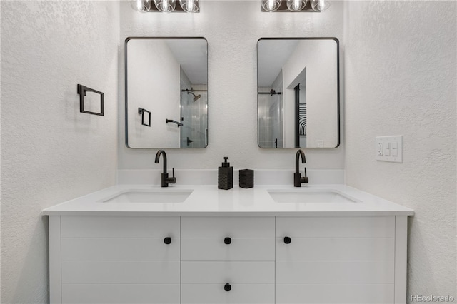 full bath with a textured wall and double vanity