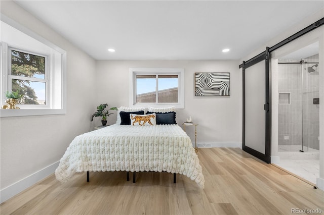 bedroom with baseboards, a barn door, light wood-style flooring, and recessed lighting