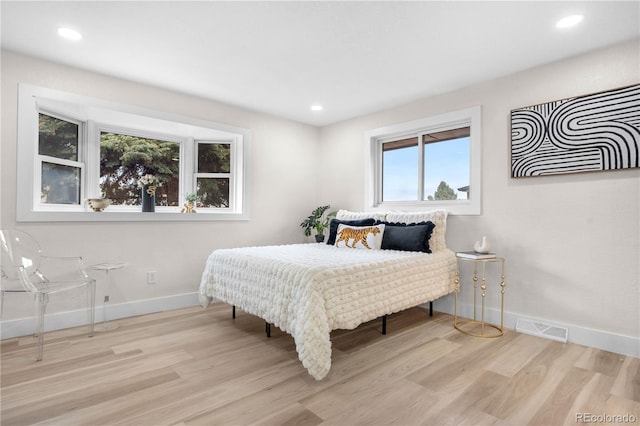 bedroom with baseboards, wood finished floors, and recessed lighting