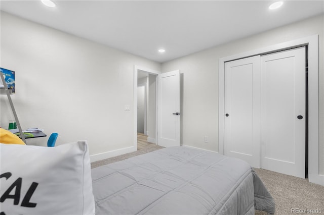 carpeted bedroom with recessed lighting, baseboards, and a closet
