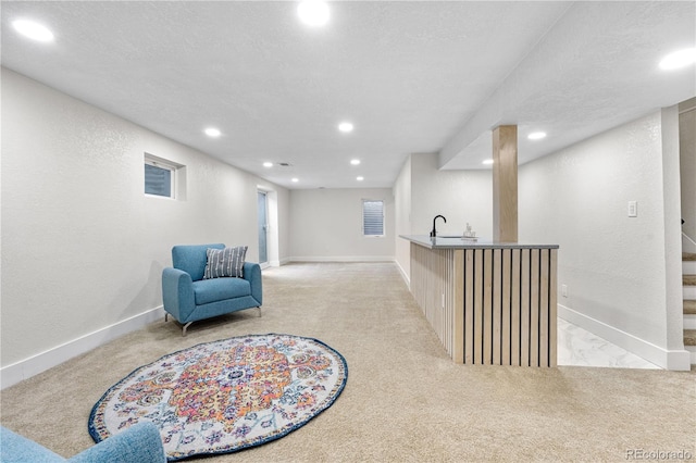 living area featuring light colored carpet, recessed lighting, stairway, bar with sink, and baseboards