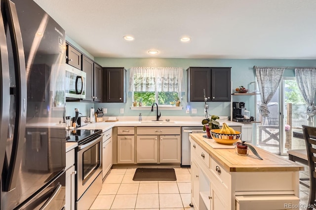 676 Hedgerow Way, Brighton, CO 80601 - kitchen featuring appliances with stainless steel finishes, butcher block counters, light tile patterned floors, healthy amount of natural light, and recessed lighting