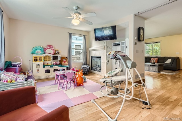 676 Hedgerow Way, Brighton, CO 80601 - workout room with a fireplace, wood finished floors, and a ceiling fan
