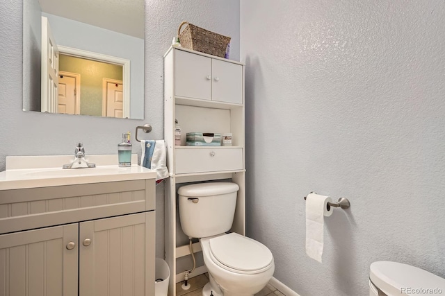 676 Hedgerow Way, Brighton, CO 80601 - half bath with vanity, a textured wall, and tile patterned flooring