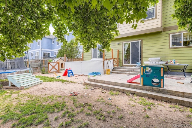 676 Hedgerow Way, Brighton, CO 80601 - fenced backyard featuring entry steps, a trampoline, a storage shed, and a patio