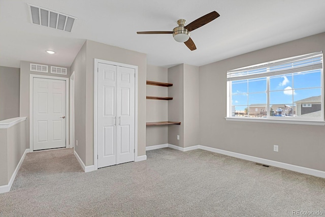 unfurnished bedroom featuring light colored carpet, a closet, visible vents, and baseboards