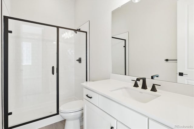 bathroom with wood-type flooring, vanity, toilet, and walk in shower