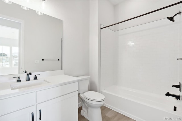 full bathroom with vanity, toilet, wood-type flooring, and tiled shower / bath