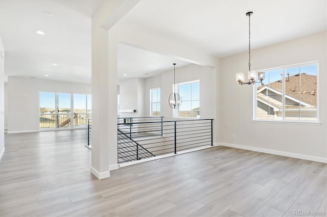 empty room featuring a healthy amount of sunlight and light hardwood / wood-style floors