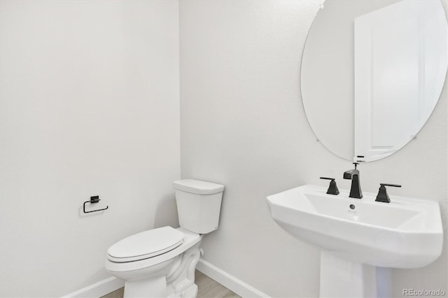 bathroom featuring sink, hardwood / wood-style floors, and toilet