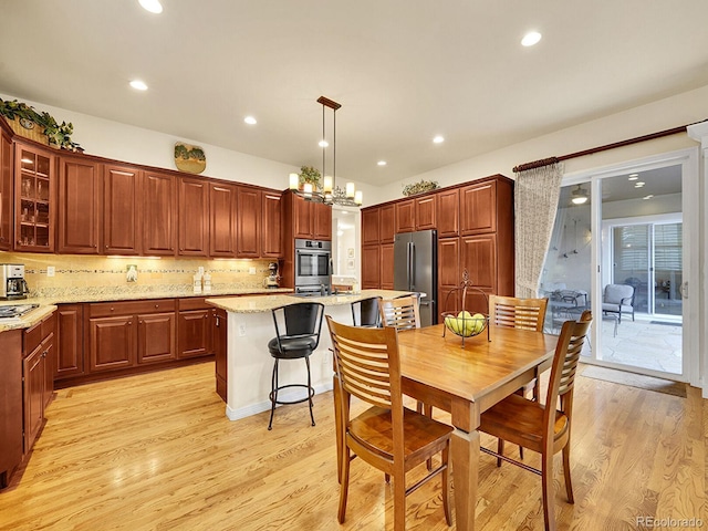 2571 Hunters Pl, Highlands Ranch, CO 80129 - kitchen featuring light wood finished floors, glass insert cabinets, appliances with stainless steel finishes, and a center island