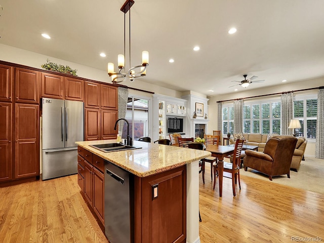 2571 Hunters Pl, Highlands Ranch, CO 80129 - kitchen with a sink, dishwashing machine, light wood finished floors, open floor plan, and stainless steel fridge