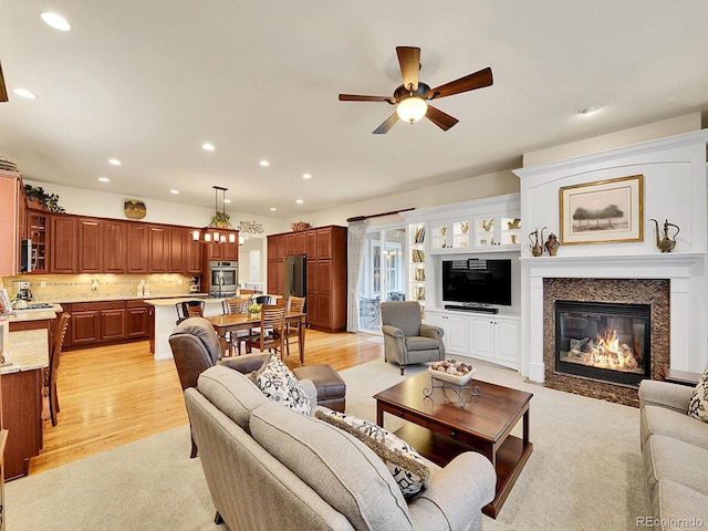 2571 Hunters Pl, Highlands Ranch, CO 80129 - living area featuring light wood-type flooring, a ceiling fan, a fireplace with flush hearth, and recessed lighting