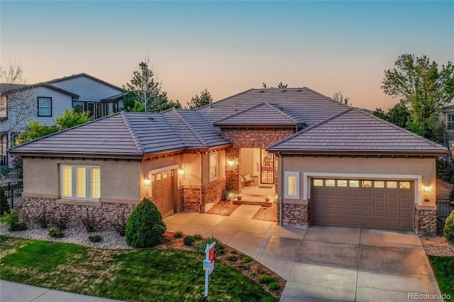 2571 Hunters Pl, Highlands Ranch, CO 80129 - view of front of home featuring stone siding, an attached garage, driveway, and stucco siding